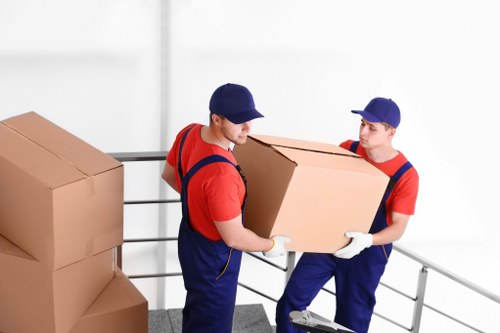 Furniture pick-up vehicle loading bulky items for collection in Holland Park