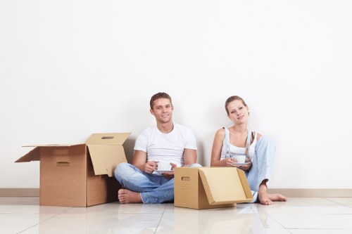 Professional movers preparing upholstered and wooden furniture for transport